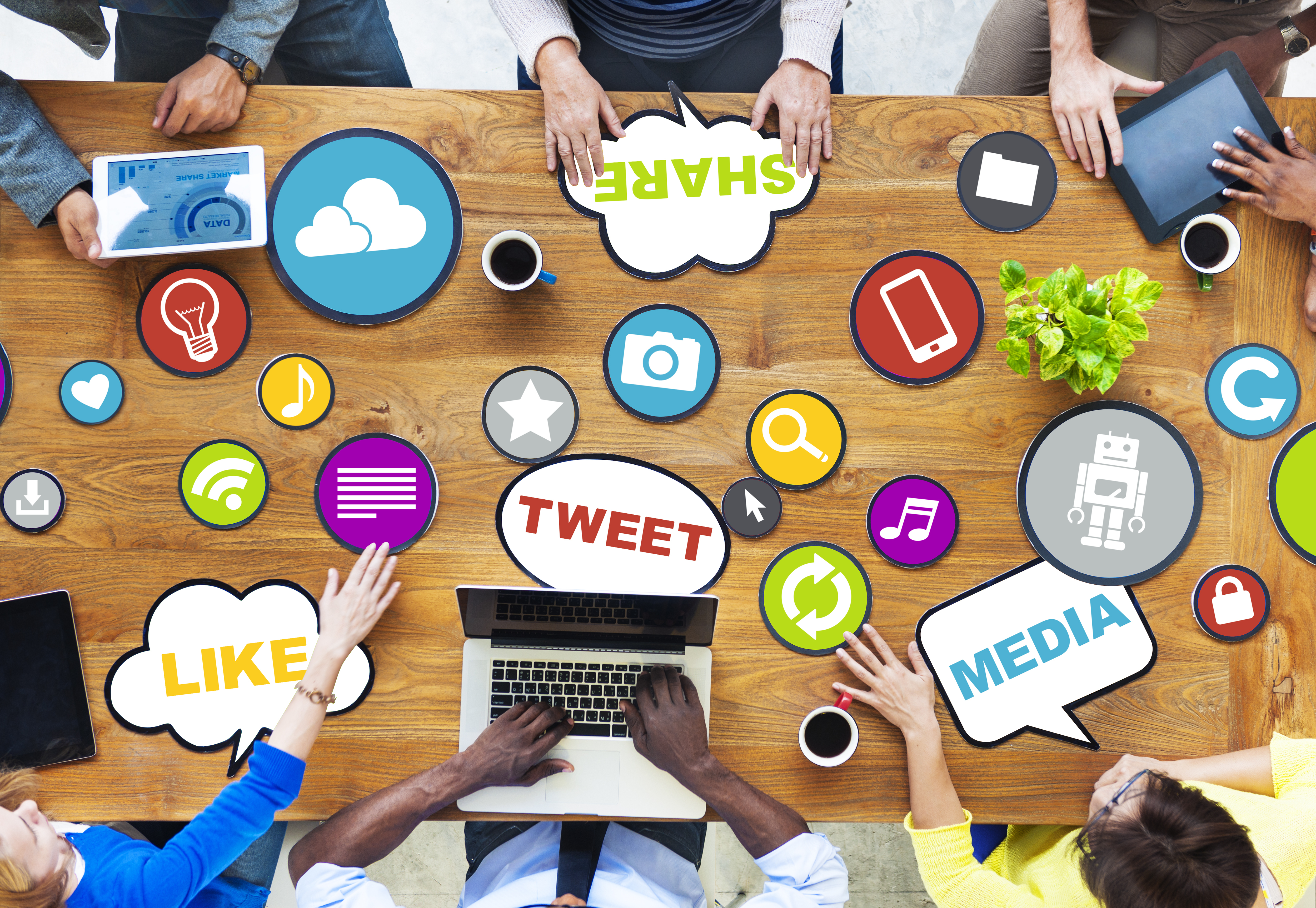 People sat around a desk with social media infographics displayed